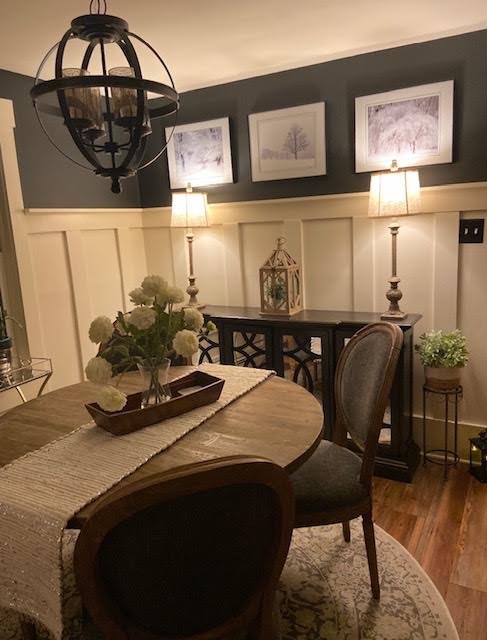 Dining room with navy walls, board and batten paneling, and an orb chandelier