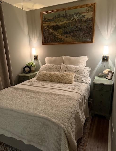 Cream bedroom with a gilt framed landscape painting and green nightstands