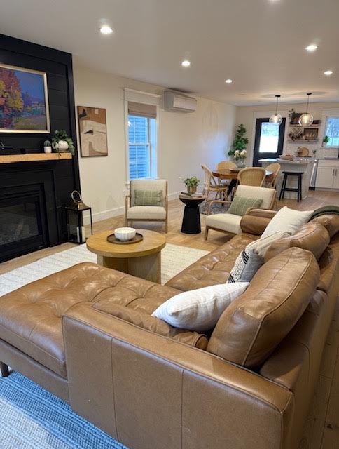 Living room with leather sectional facing a black shiplap fireplace