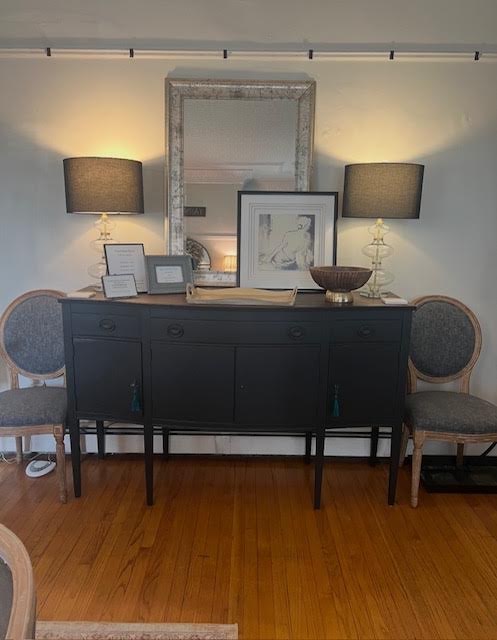 Black sideboard with matching lamps and a silver framed mirror