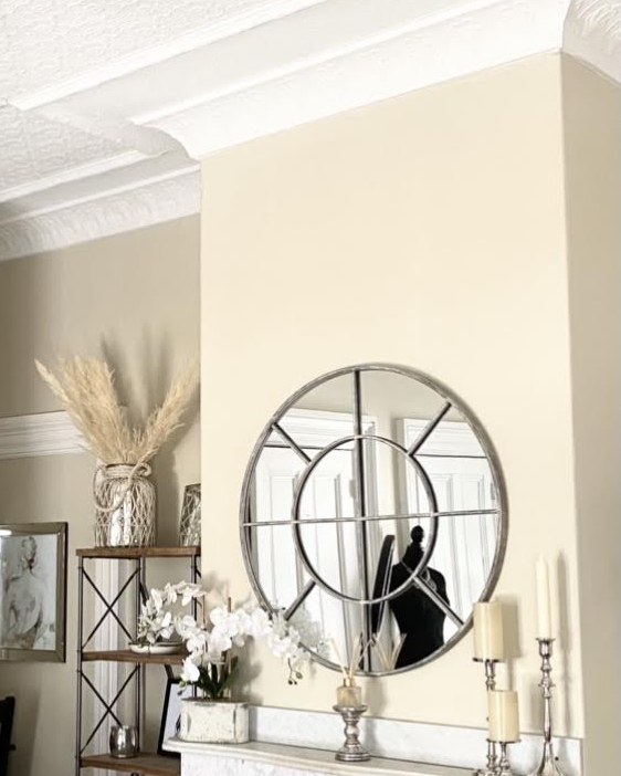 Parlor with pressed tin ceiling, marble mantel, and a round window mirror