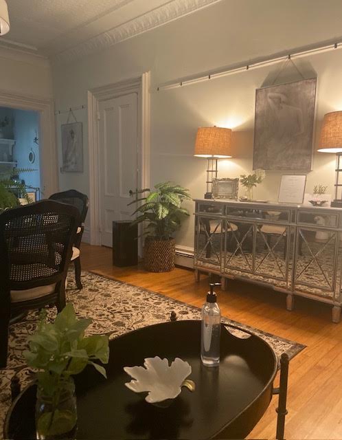 Dining area with a mirrored sideboard, paired lamps, and a patterned rug on hardwood